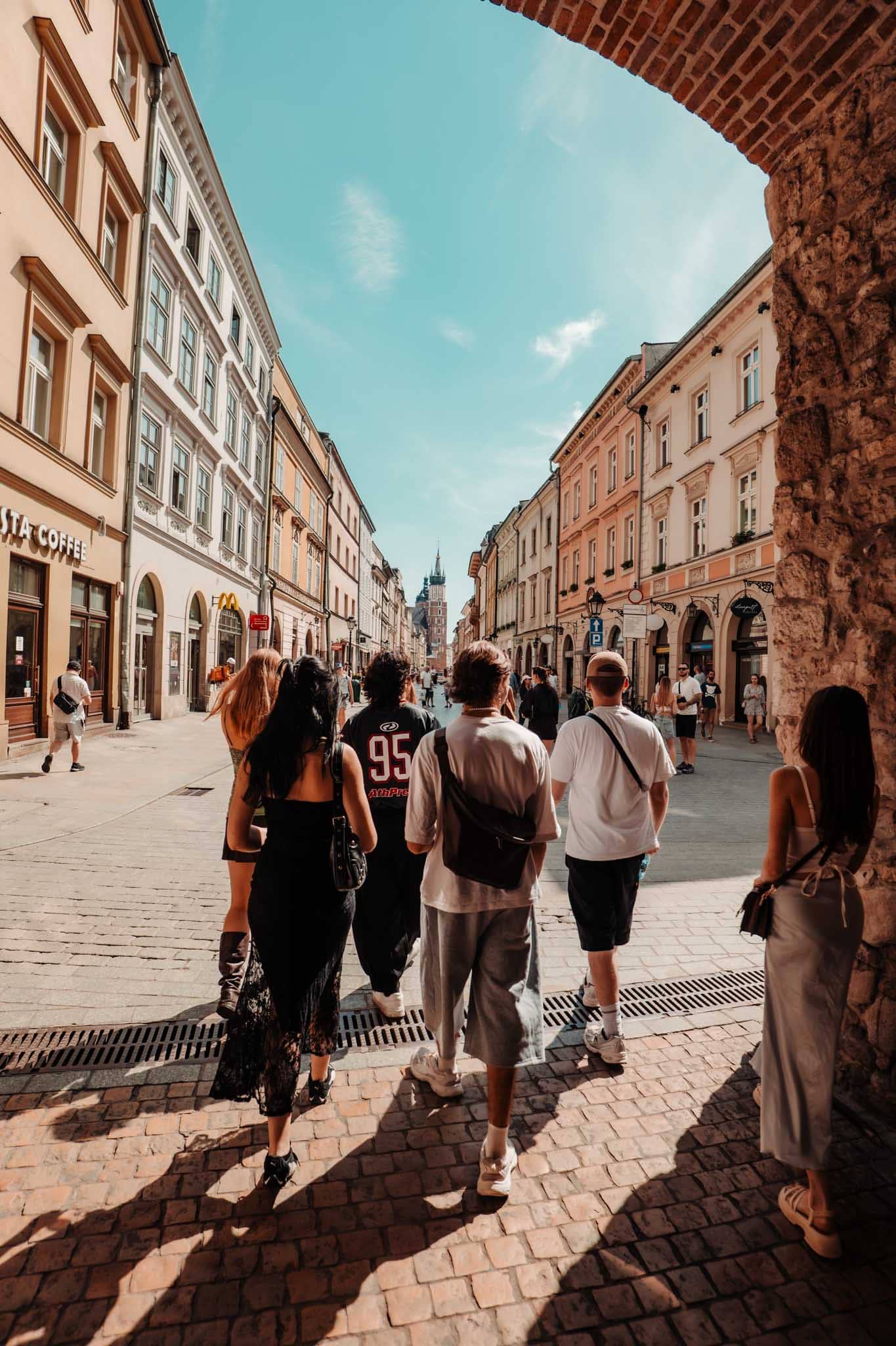 Travelers walking through Krakow Old Town
